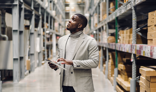 Man in a warehouse taking notes