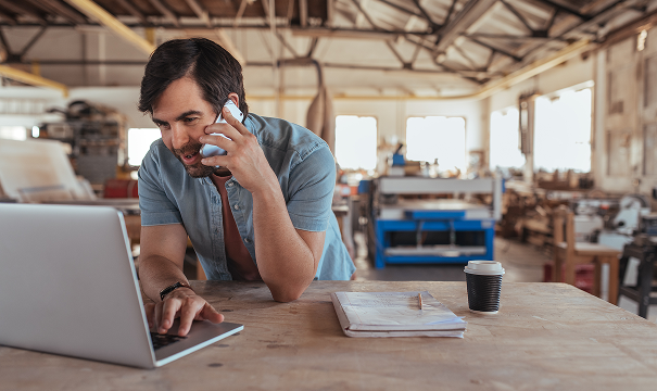 Man working at his laptop on the phone