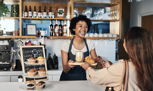 Woman in small businesses handing out pastries